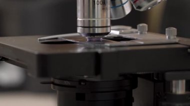 Bilim adamı bir laboratuvarda bileşik mikroskop kullanıyor. Objektif lenslere yakın çekim. Biyoteknoloji, Bilim, Kimya.