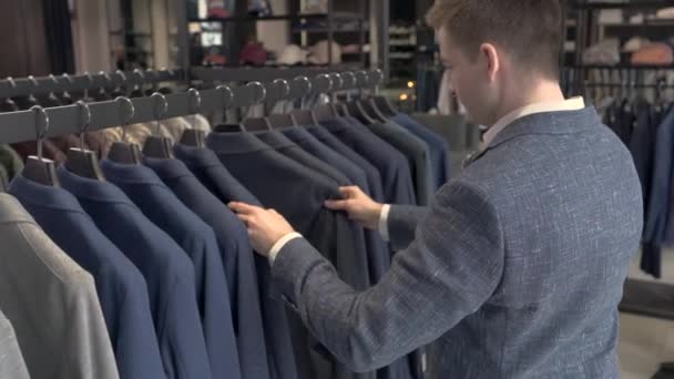 Впевнений Молодий Чоловік Дивиться Куртки Шоу Румі Чоловічого Бізнесу Магазину — стокове відео