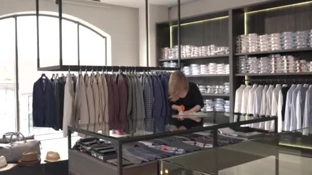高級ファッション店で商品のガラスディスプレイを掃除する店主 — ストック動画