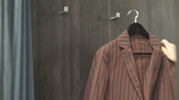 Крупный План Продавца Приносящего Разноцветную Мужскую Куртку Примерочную Предложить Одежду — стоковое видео