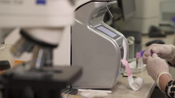 在实验室工作的研究人员 科学家使用血液分析仪 背景为现代实验室设备 选择性对焦射击 — 图库视频影像
