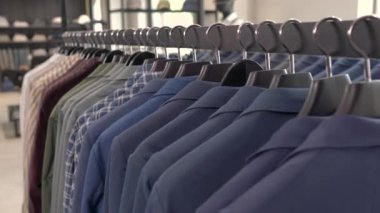 Metal büfede farklı erkek giysileri olan bir elbise askısı. Yakın çekim gösterisi. Lüks moda mağazası kavramı