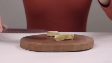 Erimeden önce organik sabun tabanı kesen bir kadının yakın çekimi. Ev yapımı sabun yapıyorum. Doğal organik kozmetik ürünleri, bitkisel ürünler. Cilt bakımı kavramı