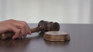 Yargıç tokmağı vuruyor, emir ya da dikkat, adalet, açık mahkeme. Yargıç çekice sert vuruyor.