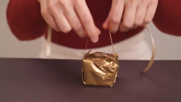 一个女人把黄色丝带绑在小包上的特写 女人在包装好的礼品盒上鞠躬 — 图库视频影像