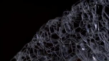 Sabun köpüğü dönüşümüne yakın çekim. İzole edilmiş, siyah arkaplanda