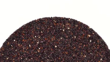 Dönen bir avuç dolusu siyah kinoa tohumu. Egzotik tahıllar, sağlıklı gıda konsepti. İzole edilmiş, beyaz arka planda. Boşluk görüntüsünü kopyala