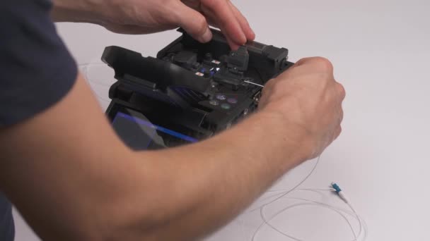 男性技术人员用把玻璃熔融在一起的机器把两根光纤因特网电缆连接在一起的特写 — 图库视频影像