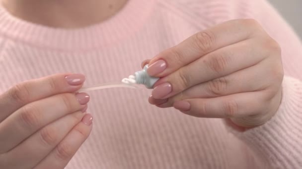 女性手牵着塑料化妆品勺并涂上奶油的特写镜头 护肤概念 — 图库视频影像