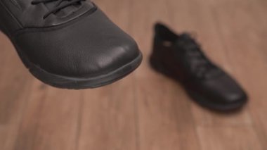 Siyah bir ayakkabı tutan ve onu kremle cilalayan bir adam. Ayakkabı bakımı için profesyonel ürünler