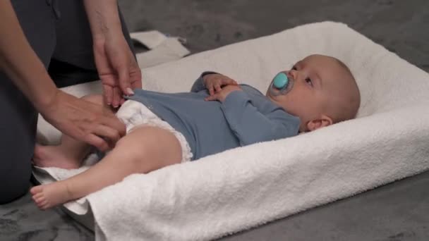 可爱快乐的小男孩穿上衣服 妈妈在更衣室里给孩子穿衣 身穿蓝色婴儿背心的婴儿 — 图库视频影像
