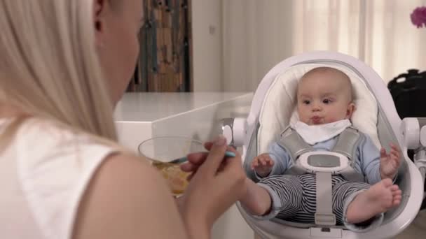 Madre Joven Alimentando Con Puré Frutas Hijo Bebé Encantador Elegante — Vídeos de Stock