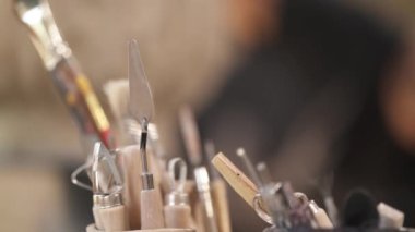 Potter seramik tencereyi parlatıyor. Çamur kalıp sanatçısı ve atölyedeki vazo dekorasyonundan esinlendim. Seçici odak atışı