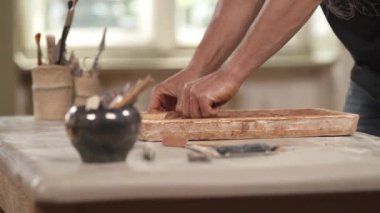 Potter seramik tencereyi parlatıyor. Çamur kalıp sanatçısı ve atölyedeki vazo dekorasyonundan esinlendim. Seçici odak atışı