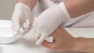 Hastanın parmağından kan örneği alan bir doktorun ön görüntüsü. Tıbbi kontrol kavramı