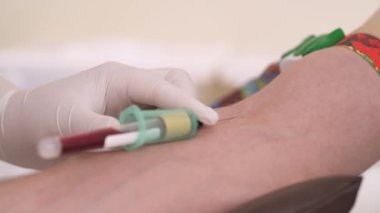 Doktor, tıbbi laboratuardaki bir hastanın damarından kan örneği alıyor. Pediatri konsepti. Yakın çekim, izole edilmiş..