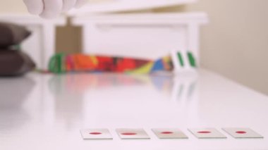 Test yapmak için mikroskop gözlüğü alan bir tıbbi teknisyenin yakın çekimi. Tıbbi laboratuvarda tam kan sayımı (CBC). İzole edilmiş, arka planda