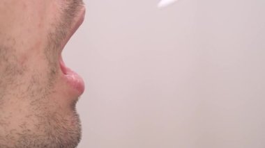 Tıp laboratuarında tükürük testi yapan bir doktor. Yakın çekim gösterisi. İzole edilmiş, bulanık arkaplanda, kopyalama alanı