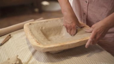 Çamur tabaklarını şekillendiren kadın çömlekçi elleri. Seramik el yapımı ürün. Atölyede çalışan sanatçı.