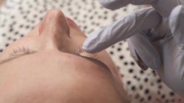 Prosedürden önce kaş üzerinde anestezi uygulayan kalıcı makyaj uzmanı. Güzellik, makyaj ve moda konsepti