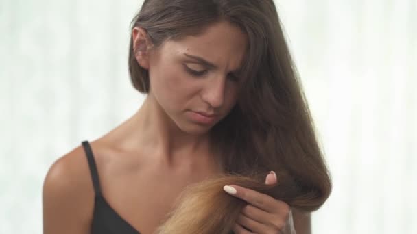 Femme Tenant Ses Cheveux Longs Regardant Les Extrémités Cassantes Endommagées — Video