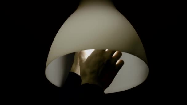 Mann Schraubt Glühbirne Die Lampe Isoliert Auf Dem Schwarzen Hintergrund — Stockvideo