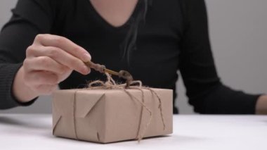 Bir hediyeyi balmumuyla mühürlemenin yan görüntüsü. Balmumu damgası. Eski ve eski tarz. İzole edilmiş, seçici odak atışı
