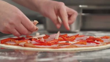 Pizzaya dilimlenmiş mantar koyan bir şefin yakın çekimi. İtalyan geleneksel yemek hazırlığı. Fast food konsepti