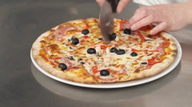 Profesyonel şef paten bıçağıyla birkaç dilim pizza keser. Fast food konsepti