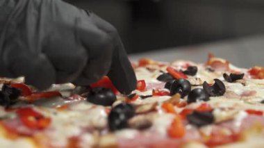 Pizza pişiriyorum. Kadın eli taze pişmiş pizzayı süslemek için birkaç parça domates koyuyor. İtalya kavramı, yemek ve diyet.