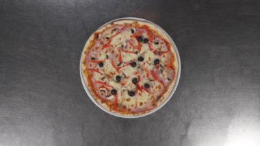 Erkek ellerinin lezzetli bir pizzayla tabağı götürdüğü yakın çekim. Peynirli ve taze domates soslu tipik İtalyan yemeği. İtalyan yemeği kavramı, İtalya, restoran pizza geleneği