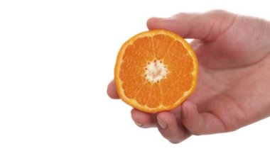 Erkek el ele tutuşması ve olgun Kleopatra Mandarin 'in yarısını sıkmak. Citrus suyu damlıyor. İzole edilmiş, beyaz arkaplanda