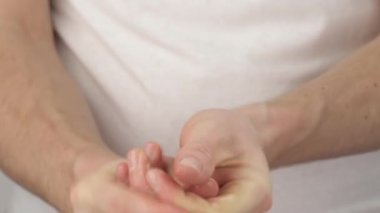 Beyaz tişörtlü beyaz bir adamın önü yıkanmadan önce ellerini suyla ıslatıyor. Yakın çekim..