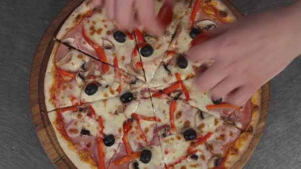 ピザを作る 焼きたてのピザを飾るために2枚のチェリートマトを入れて手のトップビュー 食と食のコンセプト — ストック動画