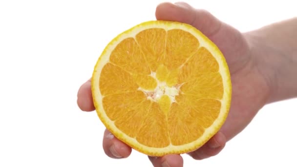絞りオレンジから落下する新鮮な柑橘類のジュース 柑橘類を絞る男性の手のクローズアップ 隔離された白い背景に — ストック動画