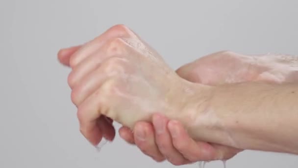 白人男性の手の側面図 彼の手をこすりつけた 石鹸泡と一緒にこすります 閉鎖だ 灰色の背景に隔離された — ストック動画