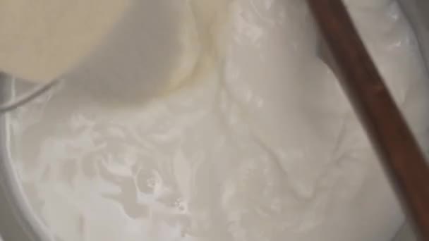 調理ベシャメルソースのクローズアップ プロのシェフが牛乳を鍋に注ぎ 木製のスプーンですべての成分と混合します 食材を調理する料理のコンセプト — ストック動画