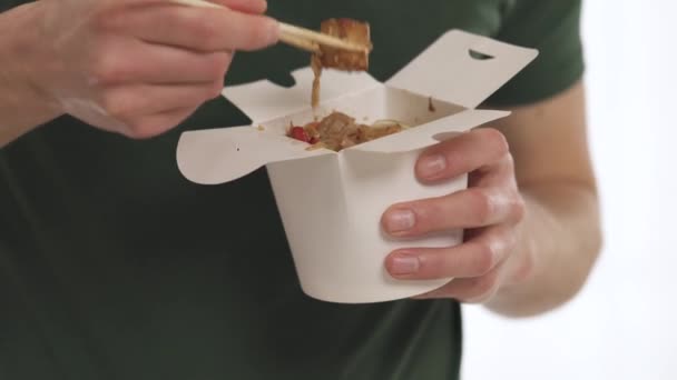 Młody Człowiek Jedzący Chiński Makaron Warzywami Używając Pałeczek Białego Pudełka — Wideo stockowe
