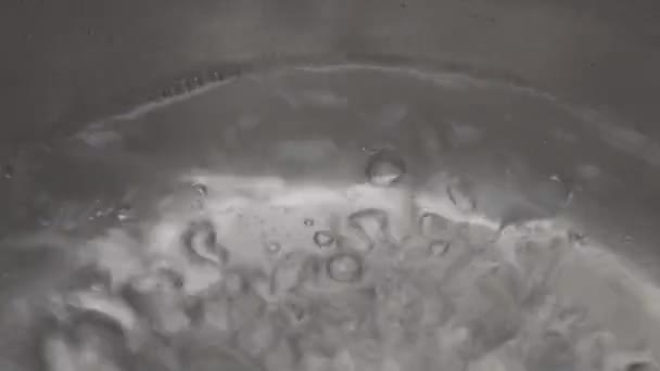沸騰した水のプロセスのマクロショット 金属鍋に泡と蒸し水のクローズアップ — ストック動画