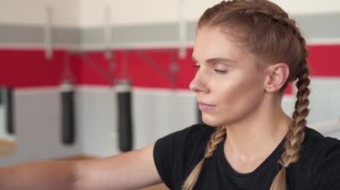 Eğitimden sonra nefes alan profesyonel bir bayan boksörün kamera çekimine yaklaşıyoruz. İzole edilmiş, bulanık arkaplanda