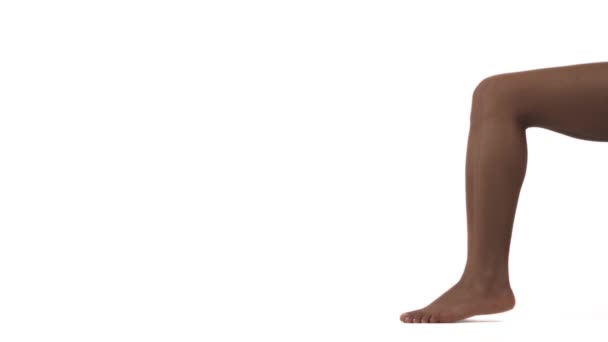 细长美丽的女性腿的特写 非洲女人站在她的脚趾 孤立无援 背景为白色 复制空间 — 图库视频影像