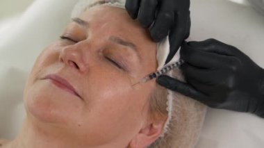 Kozmetik uzmanının mezoterapi sırasında kadınlara birden fazla iğne yaptığı yakın çekim. Biorevitalizasyon ve yüz gerdirme, cerrahi olmayan kozmetik tedavi