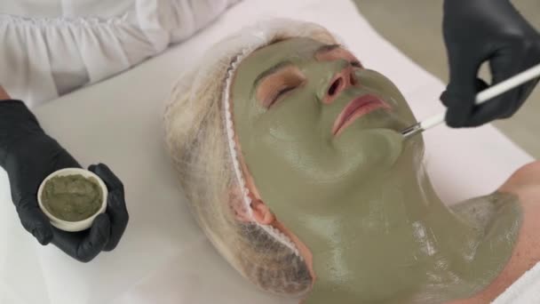 Top Widok Profesjonalnego Kosmetyczki Stosującej Naturalną Zieloną Maskę Gliny Twarzy — Wideo stockowe
