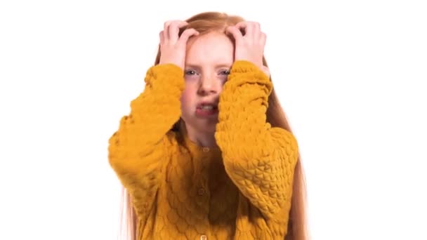一个愤怒和不高兴的女孩的特写 可爱的红头发模特做着滑稽的鬼脸 双手触摸着她的头 疯狂的面部表情 — 图库视频影像