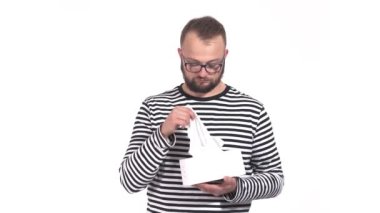 Genç yakışıklı bir adamın beyaz arka planda hapşırıp burnunu sümkürdüğü yakın çekim video.