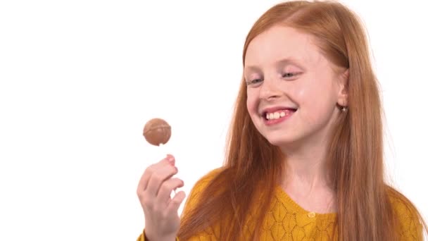 緑の目のキャンディを食べるとセクシーな髪の少女のクローズアップ 小さな子供は甘いロリポップを食べる — ストック動画