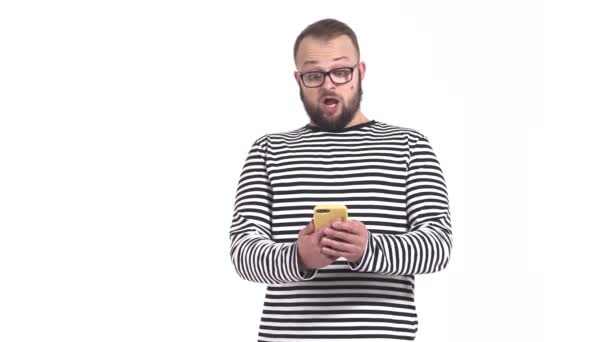 Genç Neşeli Bir Adam Akıllı Telefonuna Bakarken Kameraya Suratını Ekşitiyor — Stok video