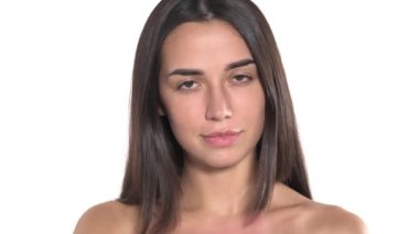 Kameraya poz veren, gülümseyen ve güzel esmer saçlarına dokunan çekici bir kadının yakın çekimi. Kamera büyüleyici sunumu