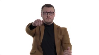 Genç bir adamın stüdyo fotoğrafı direksiyon tutuyormuş gibi yapar ve araba kullanıyormuş gibi yapar. Beyaz arkaplanda izole