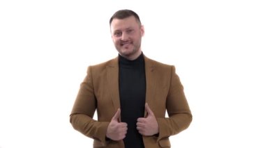 İş ve ofis kavramı. Genç ve yakışıklı iş adamı ceketini giyip baş parmağını kaldırıyor. Vücut dili ve jestler